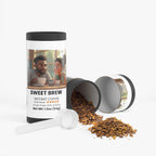 Sweet Brew instant coffee container with a lid off, showing coffee grounds, on a white background.